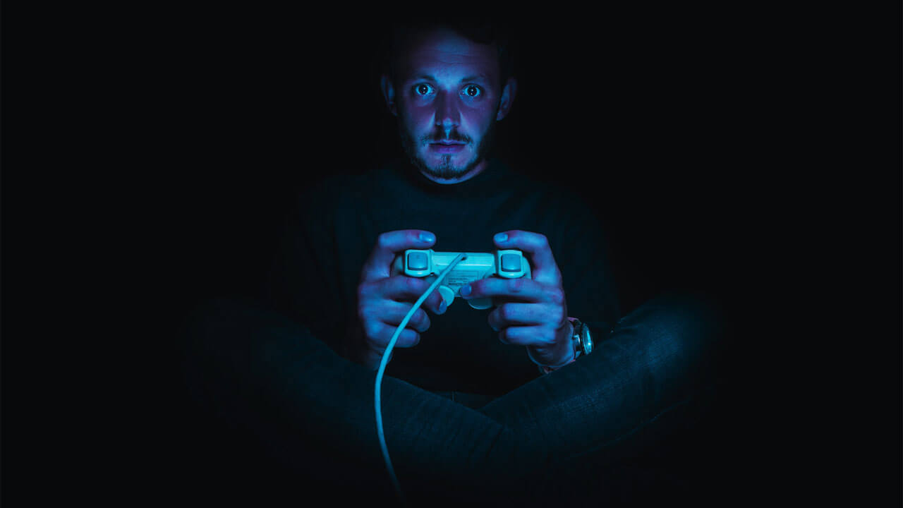 暗闇でゲームをプレイする男性